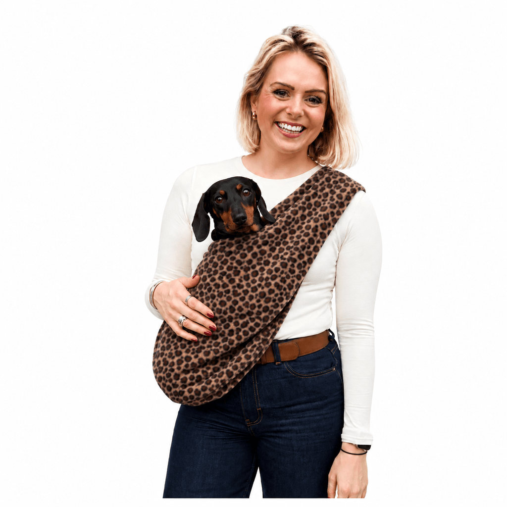 Woman carrying a dachshund in a leopard print Patterned Fleece Dog Sling