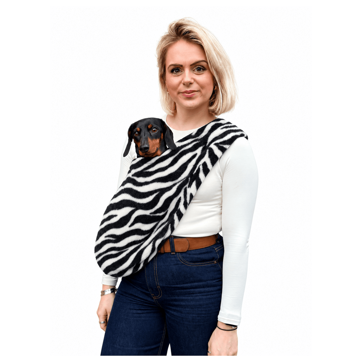 Woman wearing a zebra print Patterned Fleece Dog Sling with a black and tan dachshund