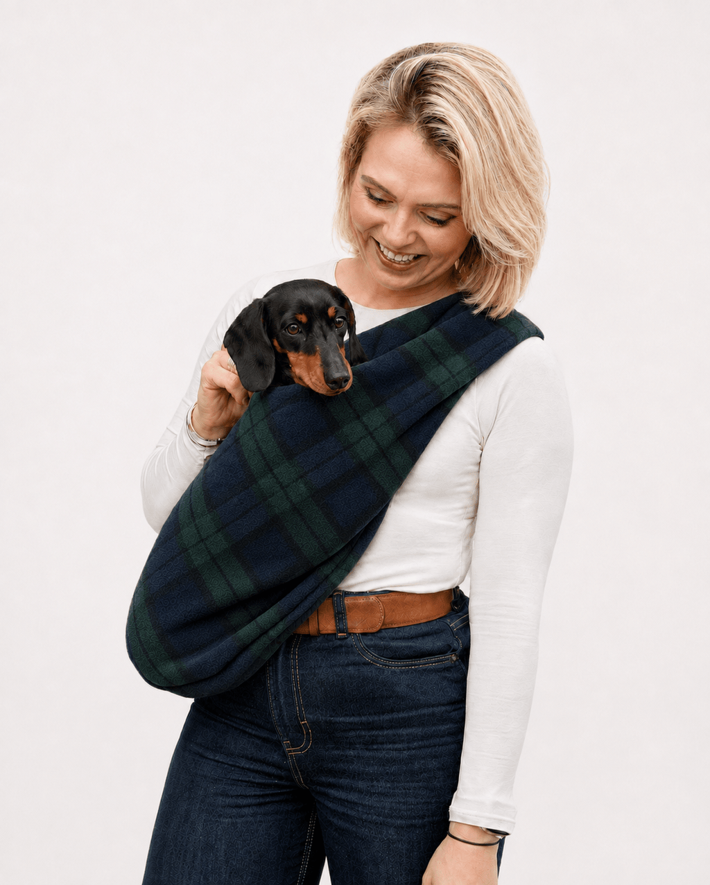 Woman carrying a dachshund in a navy tartan Patterned Fleece Dog Sling