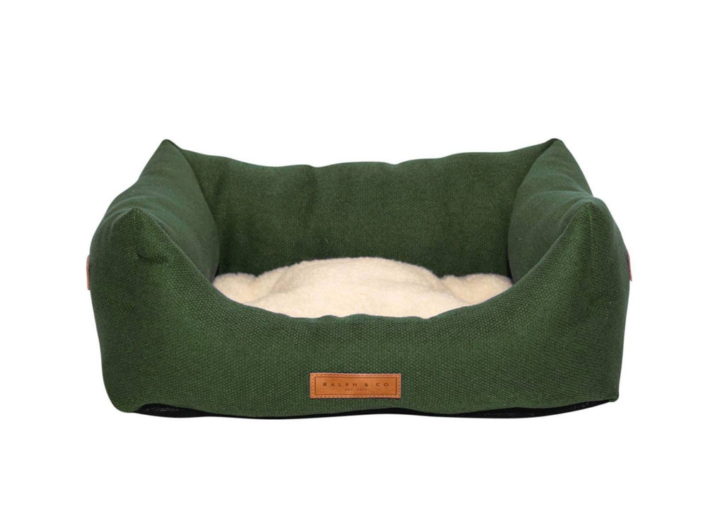 Richmond deep green bolster dog bed with cream sherpa cushion and leather badge