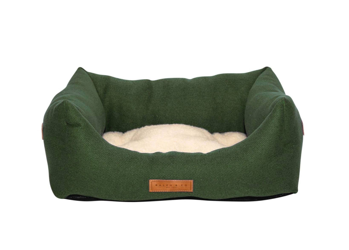 Richmond deep green bolster dog bed with cream sherpa cushion and leather badge